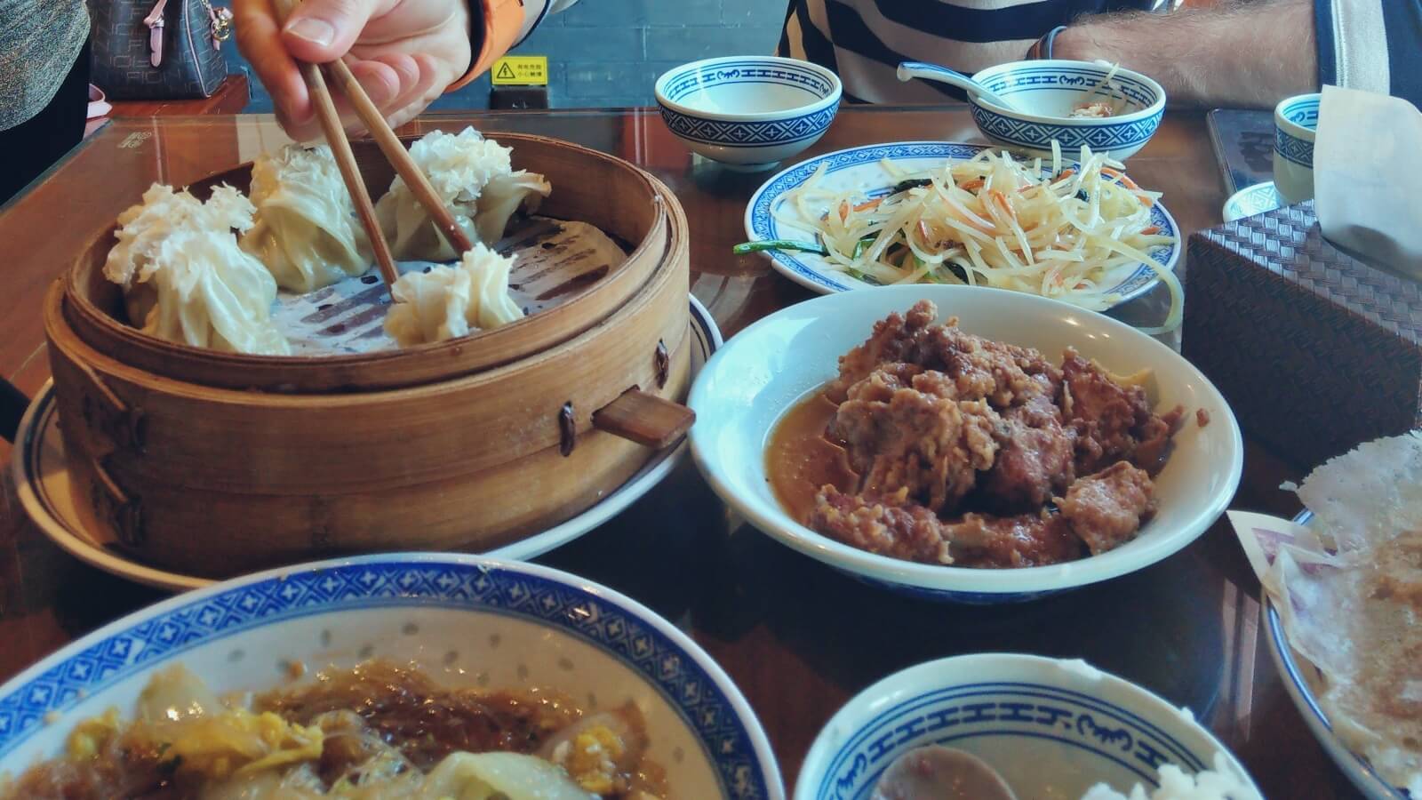 Stół zastawiony chińskim jedzeniem.